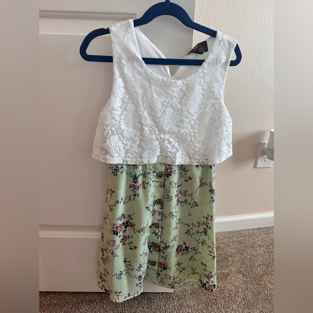 Sleeveless dress. White lace top, green floral bottom.